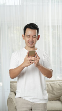 South east asian man looking at his phone with exciting face