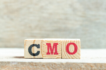 Alphabet letter block in word CMO (Abbreviation of Chief Marketing Officer, Contract Manufacturing Organization) on wood background