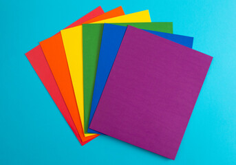 Rainbow Folders of School or Office Supplies on a Blue Background