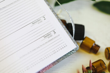 Close up image of planner opened to 3rd September surrounded by empty essential oil vials
