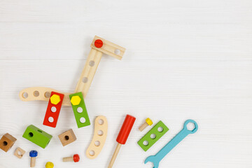 A colorful wooden giraffe and building kit for children on wood. Set of tools on white wooden table. Games and tools for kids in preschool or daycare. Natural, eco-friendly toys.