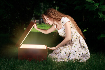 Blonde girl open mystrey box with light inside