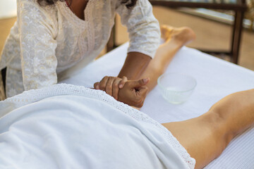 Obraz na płótnie Canvas Massagista massageando pernas da cliente