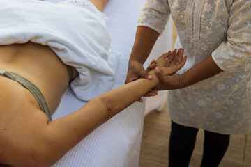 Profissional fazendo massagem relaxante no braço da cliente