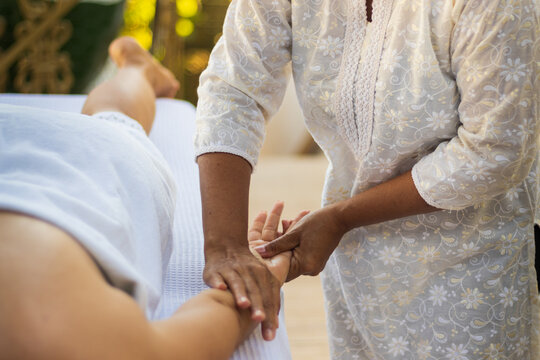 Massagista fazendo alongamento e massagem nas mãos da cliente