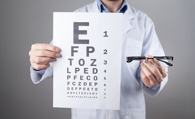 Caucasian doctor showing eyeglasses and eye examination test.