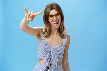Waist-up shot of confident and daring charming young woman in matching trendy clothes yelling yeah...