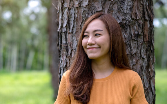 Portrait image of a beautiful young asian woman standing in the park