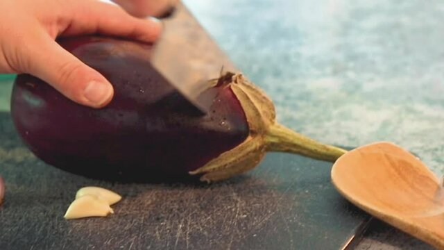 Cook cutting an eggplant