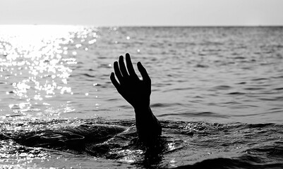 hand of the drowning person in the middle of the ocean in black