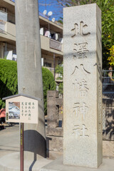 Fototapeta na wymiar reloigious stone pillar with name of shrine written on it at kitazawa hachiman shrine in tokyo, japan
