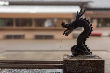 silhouette of dragon shaped statue put on washbasin of shitotomaekawa shrine in kanagawa pref, japan