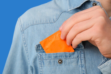 Man putting condom into pocket, closeup