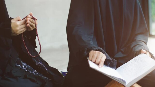 Portrait of an Asian Muslim women in a daily prayer at home reciting Surah al-Fatiha passage of the Qur'an in a single act of Sujud called a Sajdah or prostration