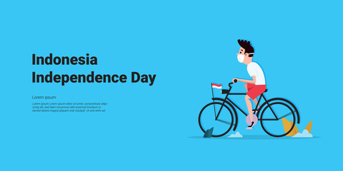 Little boy riding a bicycle and wearing a mask is leaving to celebrate Indonesia's independence day