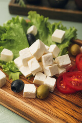 Tray with delicious pieces of feta cheese on color wooden background