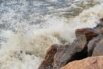 the rocky shore and the waves are beating against the stones