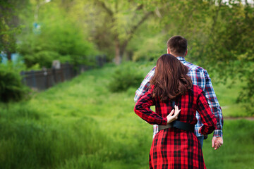 Unrecognizable Loving couple walking relaxing in summer park together. Girlfriend and boyfriend having fun outdoors. Love concept. Back view. Soft focus