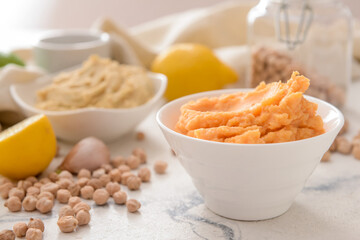 Bowl with tasty hummus on light background, closeup