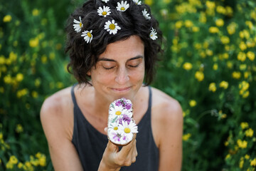 happy woman with brown flowery hair smelling and enjoying vegan cream cheese substitute whole grain...
