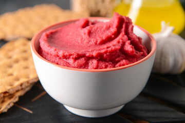 Bowl with tasty beet hummus on table, closeup