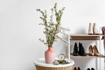 Vase with beautiful blossoming branches on table in room