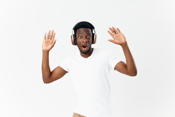 Fototapeta premium surprised African American wearing headphones music emotion entertainment light background