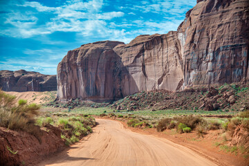 Red sand road through a beautiful canyon with blue sky.