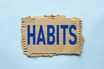 Habits, text on torn paper on blue background
