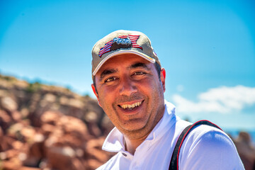 Happy man wearing hat enjoying a moment in a national park.