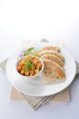 Indian vegetable bean curry with baked naan pizza bread in white background vegan dim sum Halal menu