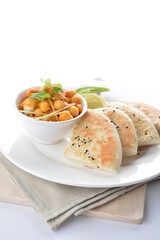 Indian vegetable bean curry with baked naan pizza bread in white background vegan dim sum Halal menu