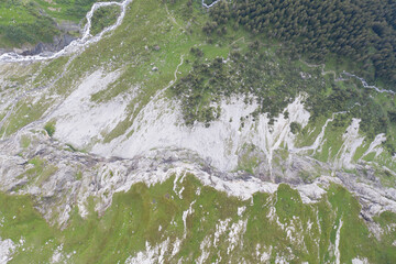 Tolle Drohneaufnahmen in den schweizer Alpen. Wundervolle gr&uuml;ne B&auml;ume und ein m&auml;chtiger Wasserfall in mitten des Waldes. Vogelperspektive.