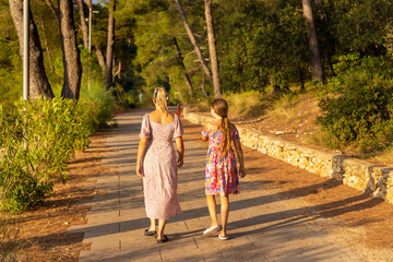 Mother and daughter are walking  on the path, Mali Losinj, Croatia