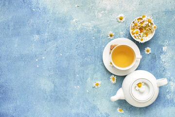 Obraz na płótnie Canvas Cup with tasty floral tea and teapot on color background