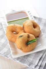 Indian vegetable deep fried donut in green yogurt and red chilli sauce in white background vegan dim sum Halal menu