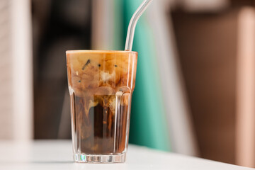 Glass of tasty iced coffee on table