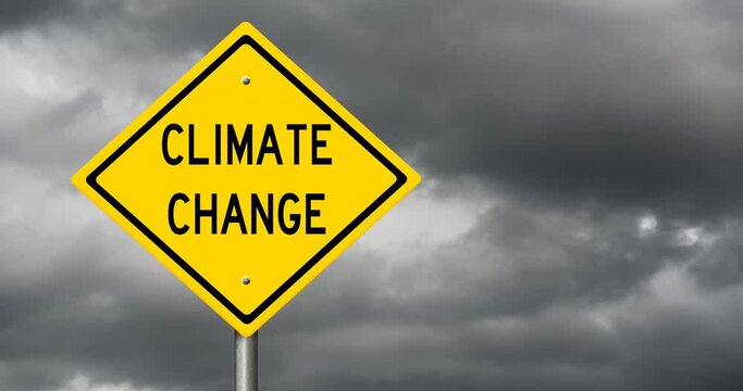 Yellow sign CLIMATE CHANGE with time lapse of dark storm clouds