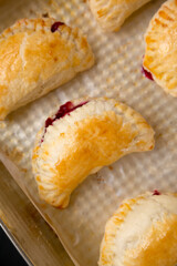 Homemade Cherry Hand Pies in a baking pan, top view. Flat lay, overhead, from above. Close-up.