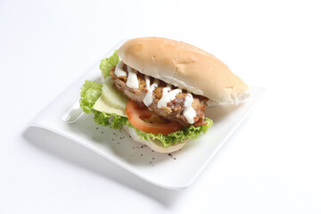 speciality grill bbq chicken burger with sliced cheese and vegetables in white background western fast food halal menu