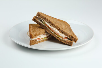 club sandwich with chicken and tomatoes on rye bread in white plate isolated. club sandwich