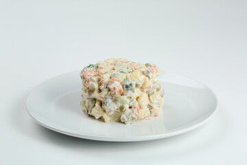 Olivier salad on white plate. vegan version of traditional russian salad Olivier from boiled vegetables.