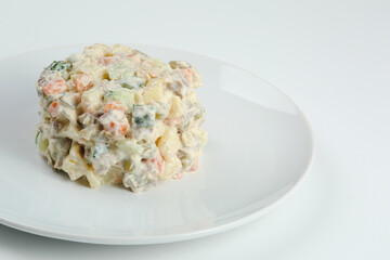 Olivier salad on white plate. vegan version of traditional russian salad Olivier from boiled vegetables.