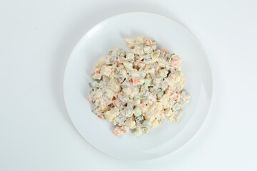 Olivier salad on white plate. vegan version of traditional russian salad Olivier from boiled vegetables.