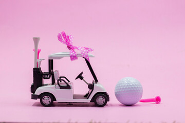 Golf cart and golf ball on pink background
