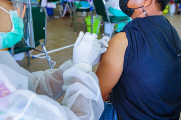 Doctor holding syringe and  make injection Covid-19 or coronavirus vaccine to patient.