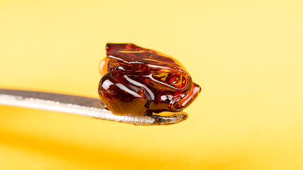 cannabis wax dab concentrate on a stick for smoking essential oils on yellow background closeup - obrazy, fototapety, plakaty