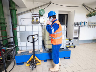 Calling worker. Industrial engineer using phone in industry room.
