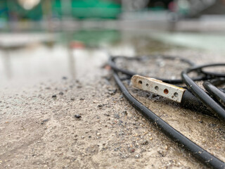 Close up view and copy space. The electric cable are on the ground flooded after rain in...