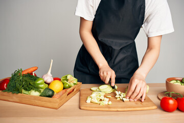 housewife in the kitchen cutting vegetables on a cutting board vitamins
